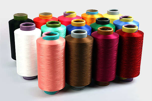 Quais são as principais vantagens do uso de fios de poliéster DTY em aplicações têxteis e como seu processo de produção contribui para sua popularidade e uso generalizado na indústria têxtil?